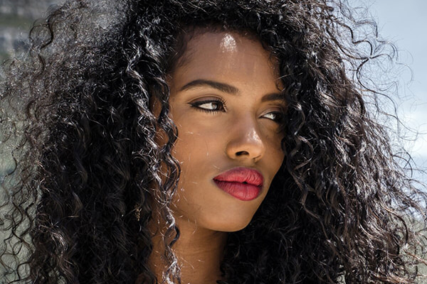 Woman glancing off to the side with dark curly hair